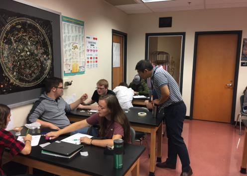 Dr. Kwon talking to a group of students in a high school classroom.